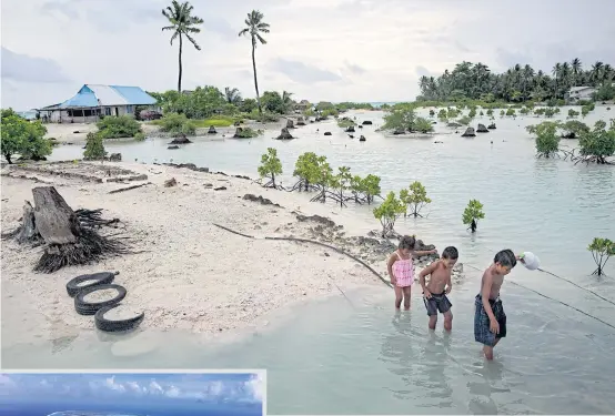  ?? PHOTOS BY THE NEW YORK TIMES ?? Children wade through water at high tide in a village in Kiribati, the Pacific islands nation. Kiribati and other vulnerable countries have yet to see any money from the Green Climate Fund to help them deal with the impact of climate change.