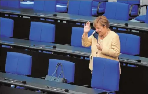  ?? // AFP ?? Merkel saluda ayer al llegar a la sesión plenaria del Bundestag en Berlín