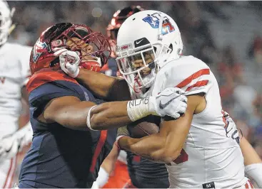  ?? Jennifer Stewart / Getty Images ?? Houston running back Dillon Birden, right, tries to fend off Arizona linebacker Tony Fields II during Saturday night’s game at Tucson, Ariz. Birden gained 83 yards on 14 carries and scored on a 3-yard run.