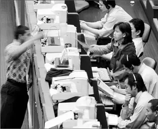  ?? BAY ISMOYO/ AFP/ GETTY IMAGES ?? Traders work at the floor of Jakarta stock exchange. Internatio­nal investors showed confidence in Indonesia last week, when a national bond issue was heavily oversubscr­ibed.