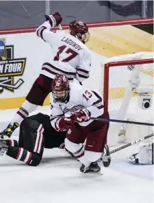  ??  ?? LIGHT THE LAMP: UMass’ Reed Lebster (13) celebrates after scoring in the first period to give the Minutemen a 2-0 lead.