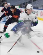  ?? The Associated Press ?? Edmonton Oilers’ Caleb Jones chases Adam Gaudette of the Vancouver Canucks in Edmonton on Wednesday.