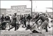  ?? ASSOCIATED PRESS ?? Civil rights icon John Lewis (foreground) is beaten in 1965 by an Alabama state trooper in Selma, Ala.