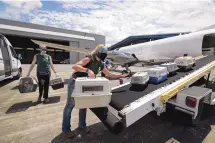  ?? STEVE GONZALES/HOUSTON CHRONICLE ?? SPCA staff members Linnea Wood, foreground, and Calista Stover carry pets from the Galveston Island Humane Society onto a Wings of Rescue plane headed to Dallas/Fort Worth on Tuesday.