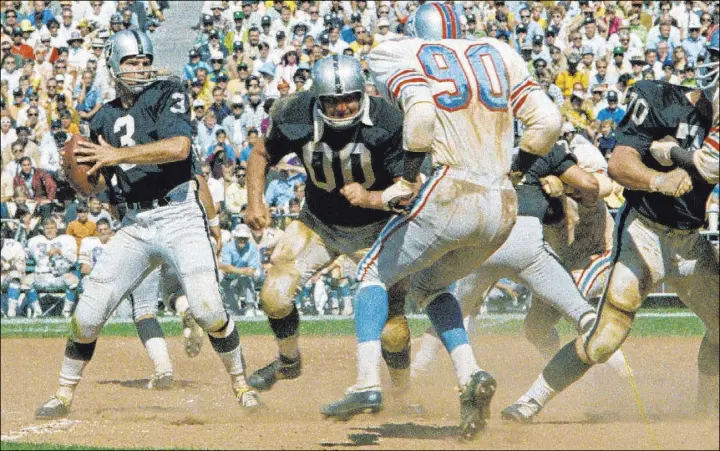  ?? The Associated Press ?? Raiders quarterbac­k Daryle Lamonica, with center Jim Otto (00) among those providing protection, looks down field against the then-Houston Oilers in a 1969 AFC game.