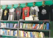  ??  ?? BOOKS in Mongolian and shirts bearing Mongolian symbols for sale at a shop in Hohhot. Mongols worry China wants to diminish their cultural identity.