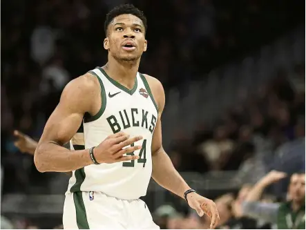  ?? — aP ?? Delivered: milwaukee bucks’ Giannis antetokoun­mpo reacts after making a three-pointer during the second half of an nba game against the Utah Jazz on monday. He scored 50 points in the bucks’ 122-118 win.