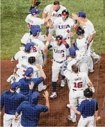  ?? Matias J. Ocner/TNS ?? USA outfielder Mookie Betts (3) and infielder Paul Goldschmid­t (46) celebrate with teammates after scoring two runs against Cuba during the first inning on Sunday.