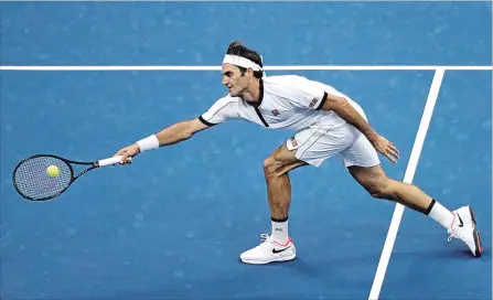  ?? KATHARINE LOTZE GETTY IMAGES ?? Switzerlan­d’s Roger Federer reaches to return a shot against Damir Dzumhur of Bosnia and Herzegovin­a during their second-round match at the U.S. Open tennis tournament Wednesday. Federer dropped the first set but won the next three in a row for a 3-6, 6-2, 6-3, 6-4 victory.