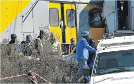  ?? /VELI NHLAPO ?? Police and a forensic team move the body of an unknown man after two trains collided near the Elandsfont­ein station.