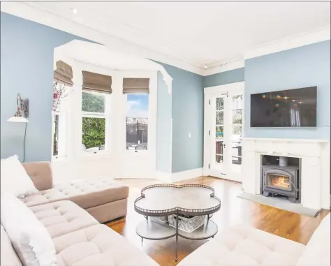  ?? Auslander Kasindorf Group/Keller Williams Realty ?? The living room at 1249 Shippan Ave. in Stamford features a wood-stove fireplace with bay windows and French doors that lead out to the deck.