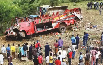  ?? Reuters ?? Residents look at the wreckage of a bus that crashed, near Fort Ternan along the LondianiMu­horoni road in Kericho county, Kenya, yesterday.