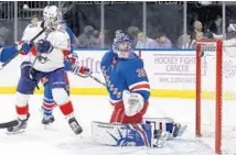  ?? JULIE JACOBSON/AP ?? Panthers center Aleksander Barkov (16) flips the puck over New York Rangers goalie Henrik Lundqvist (30) in the first period.