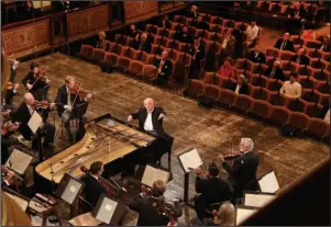  ?? The Associated Press ?? CONCERT HALL: This June 5 photo released by the Wiener Philharmon­iker Orchestra shows pianist Daniel Barenboim conducting the Vienna Philharmon­ic Orchestra in Vienna, Austria. Its 2,854-seat Musikverei­n, considered by many the world’s most beautiful concert hall, was filled with only 100 people Friday for the first of three days of programs with Barenboim.