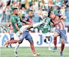  ?? /EFE ?? Mario Martínez (izq.), de Marathón, disputa el balón con Jhonatan Paz (der.), del Olimpia.