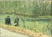  ?? MACOMB COUNTY SCANNER ?? Members of the Macomb County Sheriff’s Dive Team search a portion of the Clinton River for evidence of a hate crime attack in Warren on Wednesday.