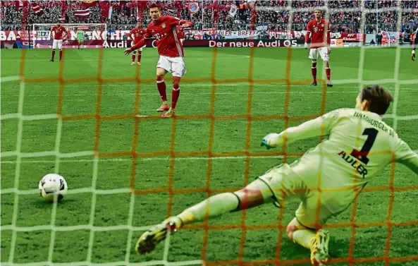  ??  ?? Spot on: Bayern Munich’s Robert Lewandowsk­i scoring from the penalty spot against Hamburg at the Allianz Arena on Saturday. — AFP