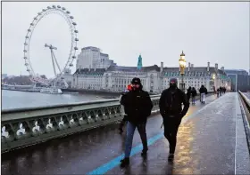  ?? (File Photo/AP/Frank Augstein) ?? Commuters walk through light snowfall Feb. 9, 2021, on Westminste­r Bridge as temperatur­es dropped below freezing in London. Stories circulatin­g online incorrectl­y claim new figures from the United Kingdom’s Office for National Statistics show that three of the country’s largest cities, London, Manchester and Birmingham, are now all “minority white.”