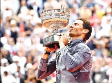  ?? AFP ?? Spaniard Rafael Nadal hoists the Roland Garros trophy after his victory in Paris last year.