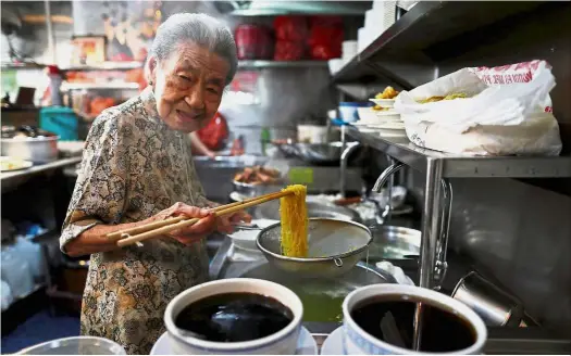  ?? — Reuters ?? Nice to mee-t you: Leong cooking noodles at her shop in Singapore.