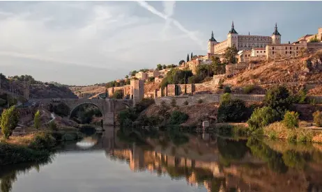  ??  ?? A la izqda., el Tajo a su paso por Toledo, con el puente de Alcántara y el Alcázar.
A la dcha., miniatura del Libro de la coronación de los reyes de Castilla, sobre la coronación de Alfonso VII, hijo de Urraca y Raimundo de Borgoña.