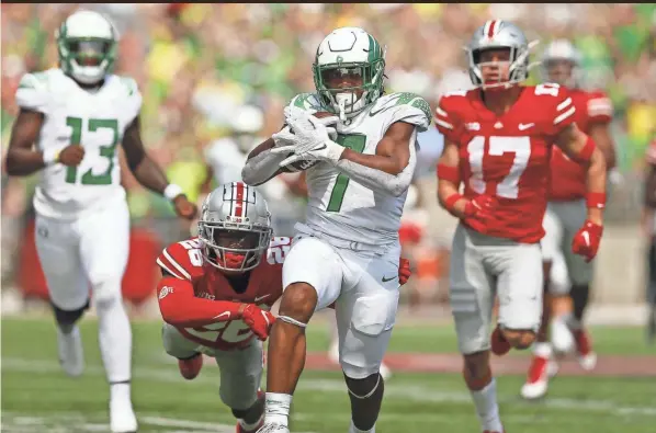  ?? ADAM CAIRNS/COLUMBUS DISPATCH ?? Oregon running back CJ Verdell runs past Ohio State safety Bryson Shaw (17) and cornerback Cameron Brown (26) for a 77-yard touchdown on Saturday. Verdell scored three touchdowns.