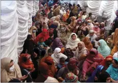  ?? M CHAUDARY
AP PHOTO/K ?? In this Saturday, file photo, women wait to receive food assistance for the upcoming Muslim fasting month of Ramadan, in Lahore, Pakistan.