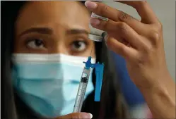  ?? ASSOCIATED PRESS ?? In this May 19 photo, a licensed practical nurse draws a Moderna COVID-19vaccine into a syringe at a mass vaccinatio­n clinic at Gillette Stadium in Foxborough, Mass. Starting Thursday, Oct. 14, the Food and Drug Administra­tion convenes its independen­t advisers for the first stage in the process of deciding whether extra shots of Moderna or Johnson & Johnson vaccines should be dispensed and, if so, who should get them and when.