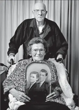  ?? Associated Press ?? Dick and Velma Scharen pose for a photo as Velma Scharen holds their wedding portrait Sunday in Springfiel­d, Ore. The photo was taken in 1937, when Dick was 18 and Velma had just turned 15. On Christmas Day, the pair, ages 93 and 90, celebrated their...