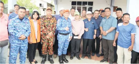  ??  ?? Uggah (fourth right), Robert (third right) are seen with DID, Civil Defence Department officials and community leaders during the visit to Kampung Bungey.