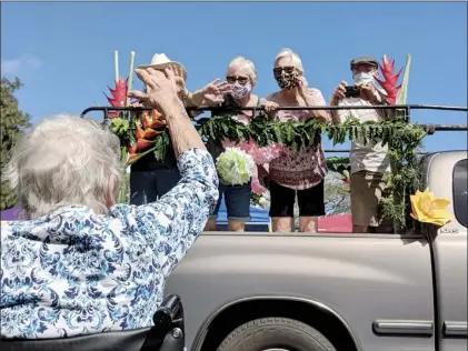  ?? HALE MAKUA photos ?? Hale Makua Kahului resident Marjorie Miller (with back to camera) waves to her family as they pass by her in the back of a truck during a Cinco de Mayo parade outside the facility Tuesday.