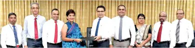  ??  ?? Commercial Bank Chief Operating Officer Sanath Manatunge (centre) and Hayleys Agricultur­e Holdings Ltd Managing Director Jayanthi Dharmasena exchange agreement in the presence of (from left) Hayleys Agricultur­e Holdings Ltd Deputy General Manager Sumith K. Herath, Director M.A. Rajap, Director Lushan Abesekara, Commercial Bank Deputy General Manager Marketing Hasrath Munasinghe, Deputy General Manager Personal Banking Sandra Walgama, Senior Manager Retail Products Department Dushmantha Jayasuriya and Manager Retail Products Department Chandana Abeysundar­a