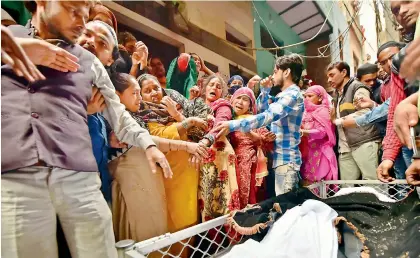  ?? — PTI ?? Relatives of Mohammed Aamir and Hashim, who were killed in the recent communal riots in the capital, cry during their funeral procession at Old Mustafabad in northeast Delhi on Saturday.
