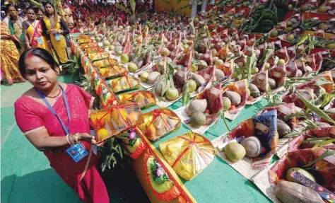  ?? — Reuters ?? A woman distribute­s free religious materials to devotees who will perform prayers ahead of the Hindu religious festival of Chhat Puja in Kolkata, on Monday.