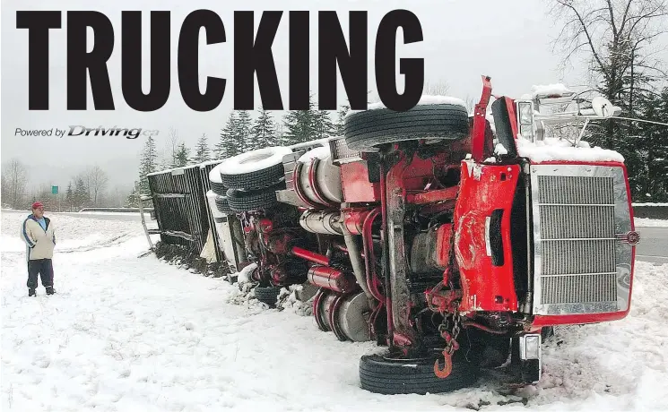  ?? IAN LINDSAY/PNG FILES ?? Winter weather left this truck lying on its side with the rear wheels of the trailer shorn off after an accident. Glen McDonald looks over the damage.