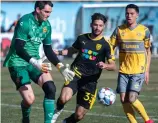  ?? EDDIE MOORE / JOURNAL ?? NM United’s Harry Swartz, middle, tries to get to the ball before Pittsburgh Riverhound­s SC goalkeeper Eric Dick, left, during last Saturday’s season opener.