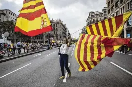  ?? SANTI PALACIOS / ASSOCIATED PRESS ?? A woman waves flags of Catalonia and Spain during a celebratio­n in Barcelona of Spain’s national day Thursday. About 65,000 people marched to a central square in the Catalan capital shouting “Long live Spain.”