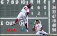  ?? MICHAEL DWYER - THE ASSOCIATED PRESS ?? Boston Red Sox’s Xander Bogaerts, left, leaps for the ball as Steve Pearce makes the catch on the fly out by Baltimore Orioles’ Cedric Mullins during the sixth inning of a baseball game in Boston, Monday, April 15, 2019.