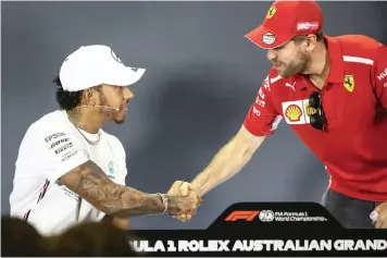  ??  ?? LEWIS HAMILTON and Sebastian Vettel shake hands before the start of a press conference at Albert Park in Melbourne yesterday. | DIEGO AZUBEL EPA