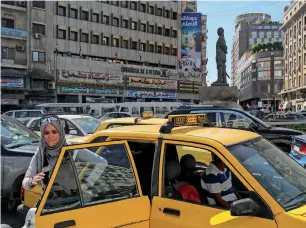  ?? AFP ?? A woman gets out of a taxi during rush hour in central Damascus, Syria. —