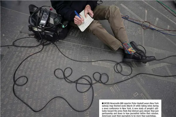  ??  ?? ■ WCBS Newsradio 880 reporter Peter Haskell wears New York subway map themed socks March 24 while taking notes during a news conference in New York. A new study of people’s attitudes toward the press finds that distrust goes deeper than just partisansh­ip and down to how journalist­s define their mission. Americans want their journalist­s to be more than watchdogs.