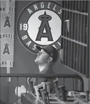  ?? Robert Gauthier Los Angeles Times ?? WITH A HEAVILY bandaged hand, Mike Trout watches Wednesday’s Angels game from the dugout.