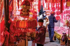  ?? Photo: NAMPA/AFP ?? People shopping on Tuesday this week for Lunar New Year decoration­s at a market in Nanning, in China’s southern Guangxi region, ahead of the Lunar New Year of the Rabbit, which falls on January 22.