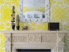  ??  ?? Susan Nelson and Todd Martz styled this mantel in a family room. The bold wallpaper called for a simple object to hang above the fireplace; the accessorie­s were chosen for their childlike qualities.