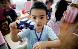  ??  ?? A boy shows off his toy car on his first day at Songjiang’s Wenxiang Kindergart­en. — Cai Bin