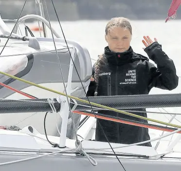  ?? AP ?? Climate change activist Greta Thunberg waves from the Malizia II boat in Plymouth, England yesterday. The 16-year-old climate change activist who has inspired student protests around the world will leave Plymouth, England, bound for New York in a high-tech but low-comfort sailboat.