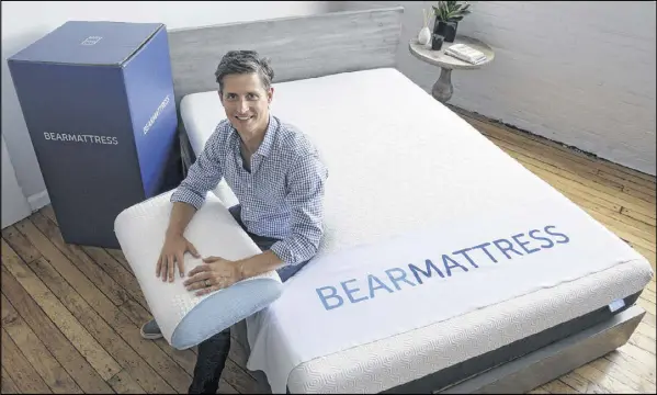  ?? AP ?? Scott Paladini, CEO of Bear Mattress, displays a sample Bear Mattress, a newly designed pillow and a shipping box in the company showroom in Hoboken, N.J. Bear Mattress has seen sales from mobile devices increase since it was launched in 2015. Half now...