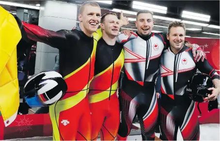  ?? ANDY WONG/THE ASSOCIATED PRESS ?? Germans Thorsten Margis, left, and Francesco Friedrich celebrate while standing next to Canadians Alex Kopacz and Justin Kripps after both teams tied for the gold medal in the two-man bobsled. Over four heats, the two sleds had a time of 3:16.86.