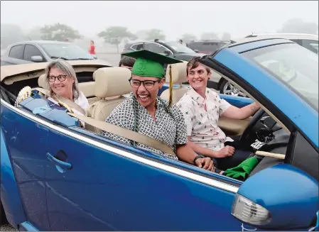  ?? SARAH GORDON/THE DAY ?? Eliza Brown laughs while sitting in a convertibl­e driven by Kris Wraight during New London High School’s drive-in style graduation on Monday at Ocean Beach. Visit www.theday.com for more photos and a list of graduates.