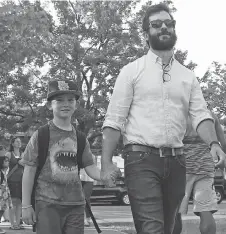  ??  ?? Lee Howard walks with his son Aron for back to school at W. E Gowling Elementary School. Lee puts a strong emphasis on having fun.